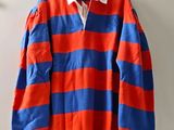 an orange and blue striped rugby shirt hanging on a wall