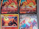quatre cartes Pokémon différentes posées sur une table avec un fond noir