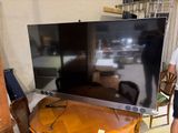 a large flat screen tv sitting on top of a wooden table