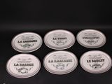 six tins of lip bales sitting on top of a black table
