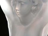 a glass sculpture of a woman with her hands behind her head