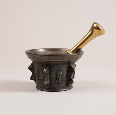 a brass mortar with a brass pestula in it