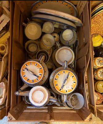 une boîte remplie d'assiettes et de tasses, ainsi qu'une horloge