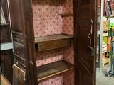 a wooden cabinet with a door open in a room