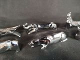 five silver animal figurines sitting on a black surface