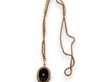 an image of a gold necklace with a black stone on it