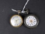 two pocket watches that are sitting on a black surface