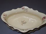a white bowl with flowers on it on a table