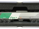 un train vert et blanc dans une boîte, posé sur les rails