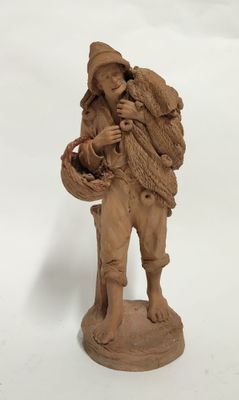 figurine représentant un homme portant un panier sur le dos
