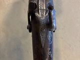 gros plan d'un pistolet avec un manche en bois sur une table