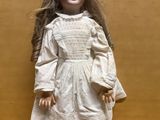 an image of a doll with long hair and a white dress