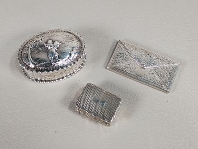 three pieces of silver jewelry sitting on top of a white surface
