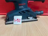 une ponceuse Black & Decker posée sur une table en bois
