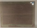 une vieille photo représentant un morceau de papier posé sur une surface blanche