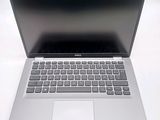 a silver laptop with a black keyboard on a white surface
