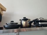 many pots and pans sitting on a shelf in the kitchen