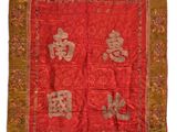 un vieux tissu chinois rouge et or orné d'inscriptions orientales