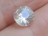 un gros plan sur la main d'une personne tenant un diamant blanc