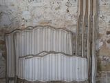 a bed that is next to a wall with a curtain