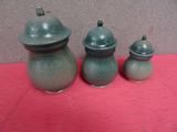 three green vases sitting on a red table