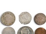 six different types of coins on a white surface