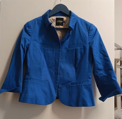une veste bleue suspendue à un cintre dans une pièce