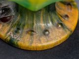 a close up of a figurine of a frog on a table