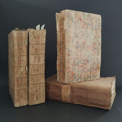 two old books stacked on top of each other on a table