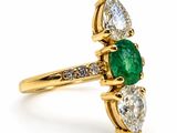 an emerald and diamond ring on a white background