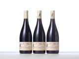 three bottles of wine sitting on top of a white table