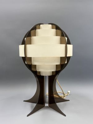 un gros plan d'une lampe posée sur un pied, sur fond gris