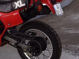 a red and black motorcycle parked in a parking lot