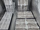 quatre vases en verre dans une boîte noire posée sur une table
