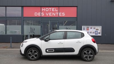 La voiture blanche est garée devant l'Hôtel des Ventes