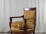 une image représentant une chaise avec un coussin posé dessus, devant un rideau blanc