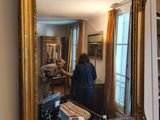 une femme debout devant un miroir dans un salon