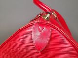 a red louis vuitton bag sitting on top of a table