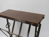 a small wooden table with metal legs and a magazine rack