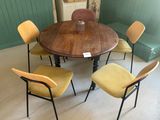 une table entourée de quatre chaises dans une pièce