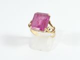 gros plan d'une bague en pierre rose sur une surface blanche