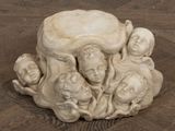 une sculpture représentant un groupe d'enfants assis sur une souche d'arbre
