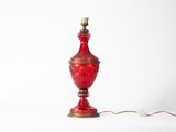 une photo d'une lampe de table en verre rouge avec un pied doré