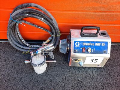 an airbrusher with hoses and a hose attached to it next to an orange wall