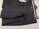 men ' s black dress pants on a table with a price tag
