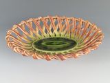 un saladier vert et marron posé sur une table blanche