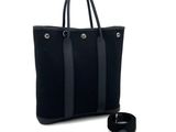 le sac fourre-tout noir se trouve à côté d'un porte-clés sur un fond blanc