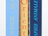 trois livres sont empilés sur une surface blanche