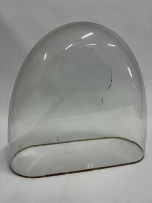 un dôme en verre percé d'un trou, posé sur une surface blanche