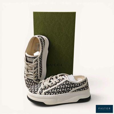 pair of black and white sneakers with a green box on a white background